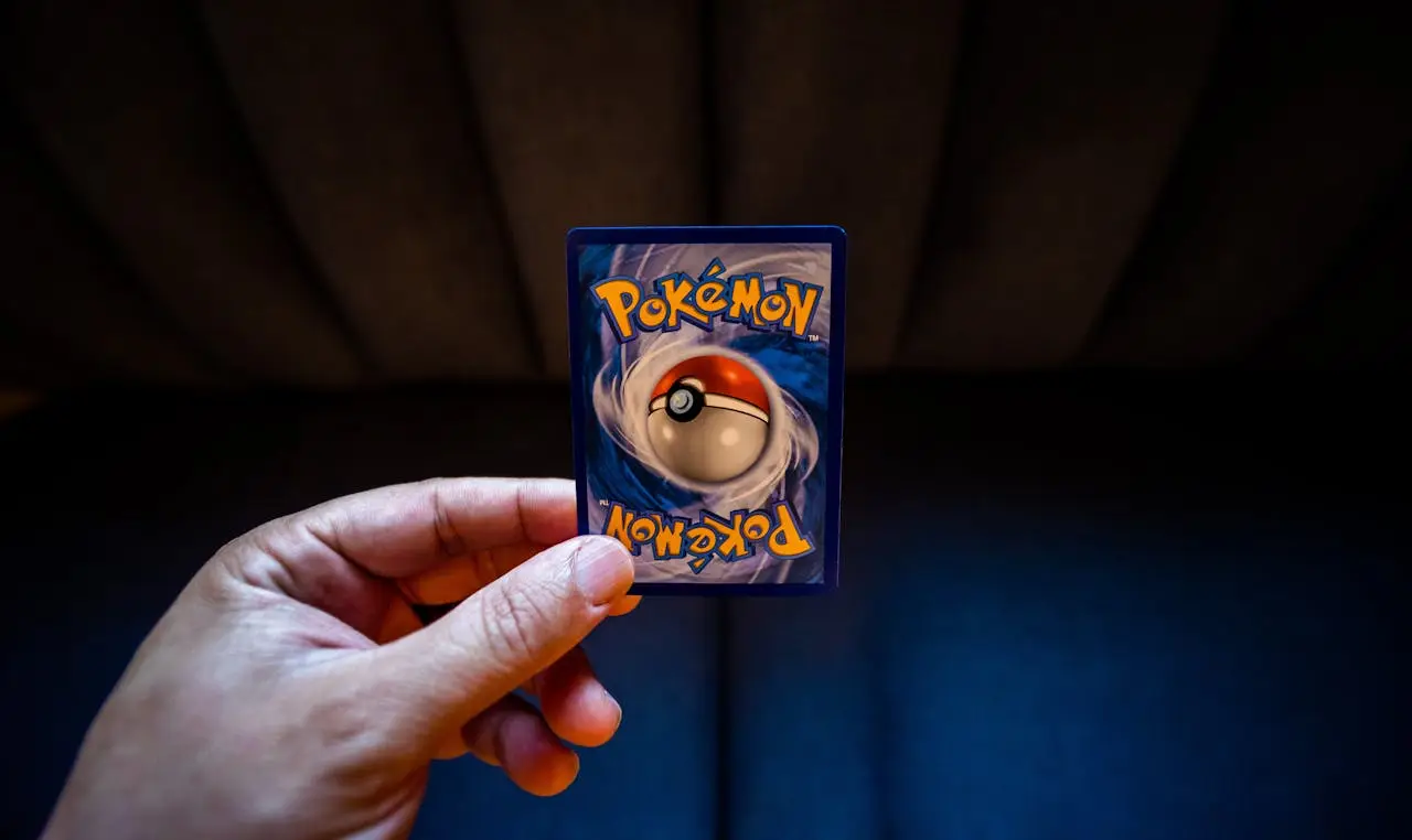 About Crop unrecognizable person demonstrating collectible card dedicated to fictional creatures on dark background