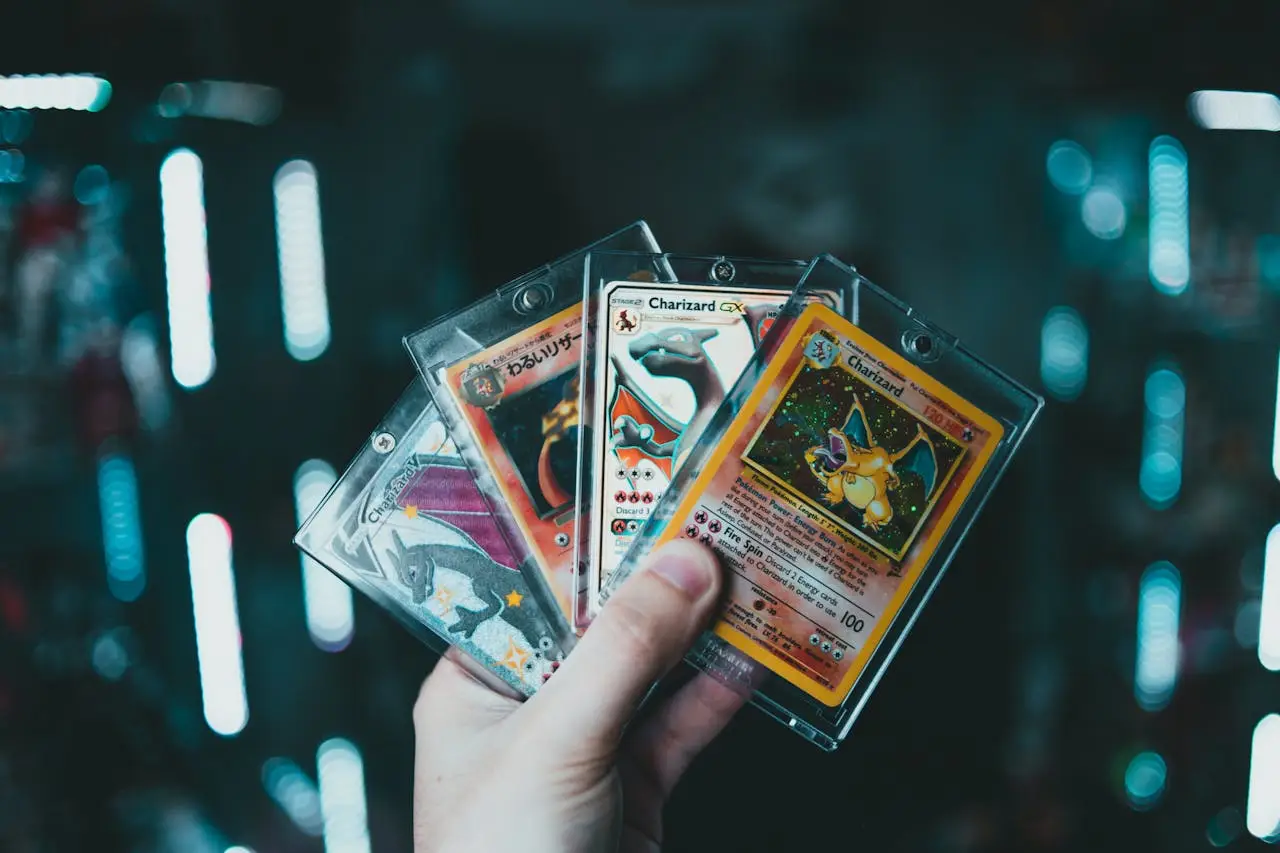 Services A hand holds collectible Charizard Pokemon cards with a blurred bokeh background. Perfect for trading card enthusiasts.